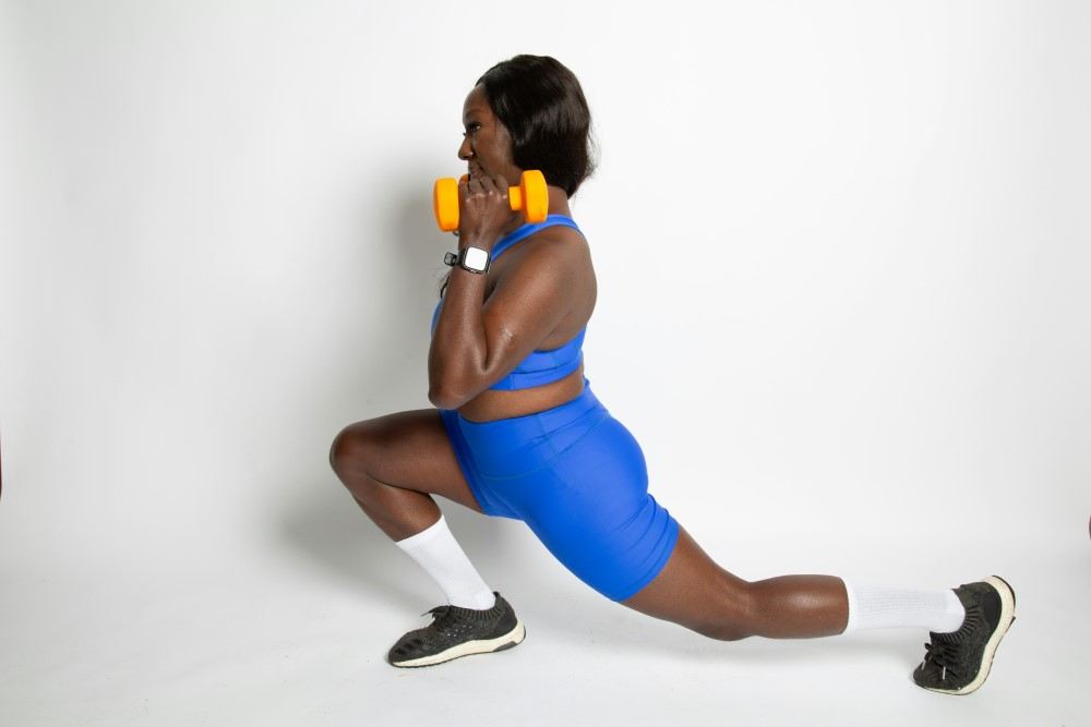Présentation d'une femme de couleur faisant des fentes et haltères pour brûleur de graisse naturel quel sport pour maigrir