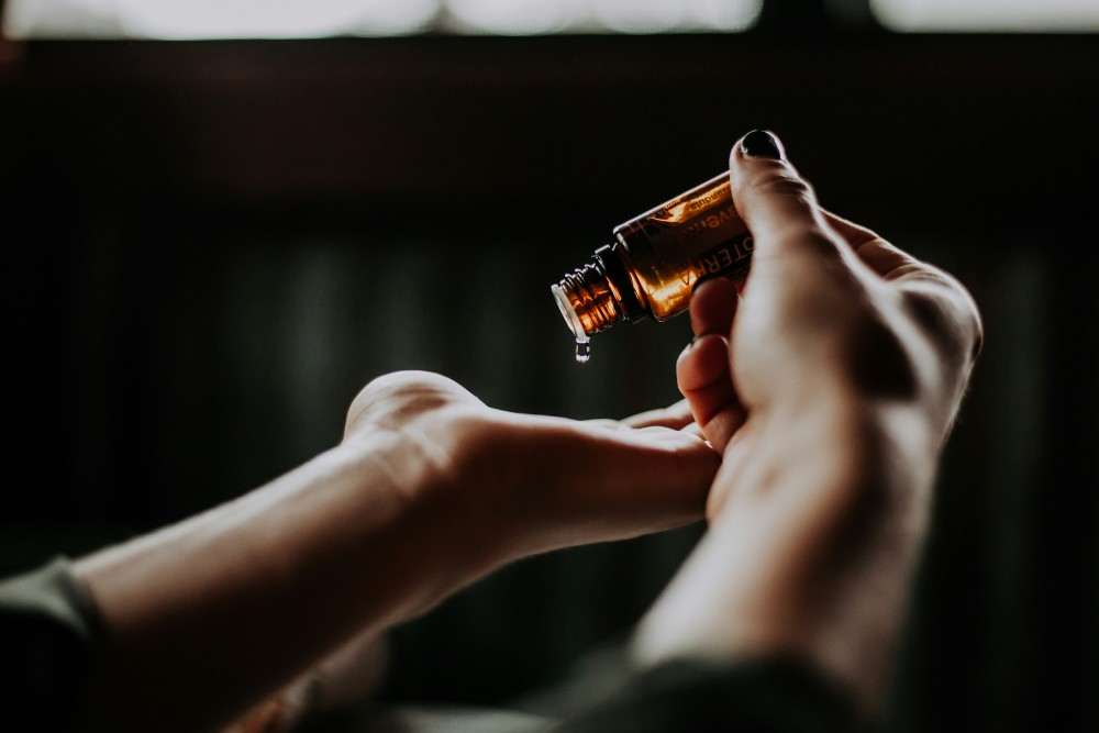 Comment utiliser les huiles essentielles, femme utilisant l'huile en massage