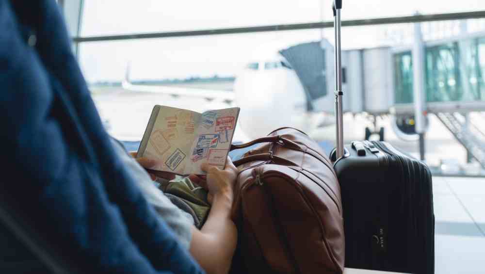 Homme regardant son passeport avant de prendre l'avion