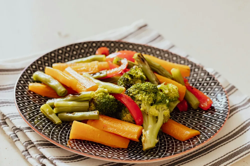 Assiette de légumes vapeur (brocolis, carottes, poivrons, haricots verts) pour une alimentation protectrice du foie