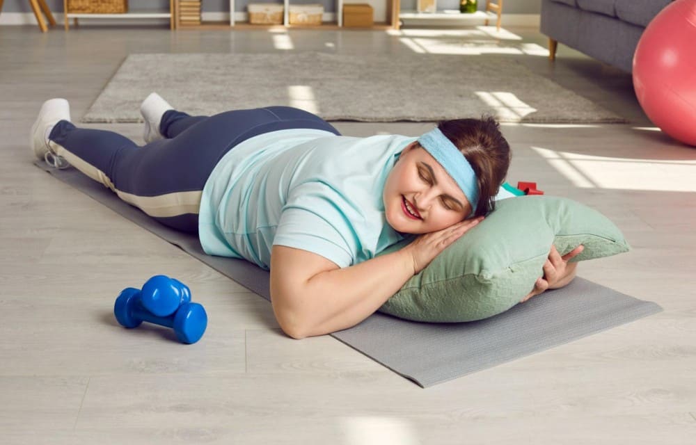 Femme allongée sur un tapis au sol ayant trouver le sommeil