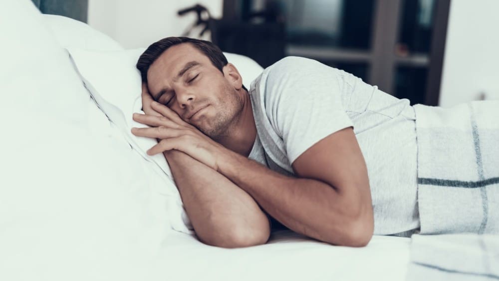 Homme qui dort dans son lit