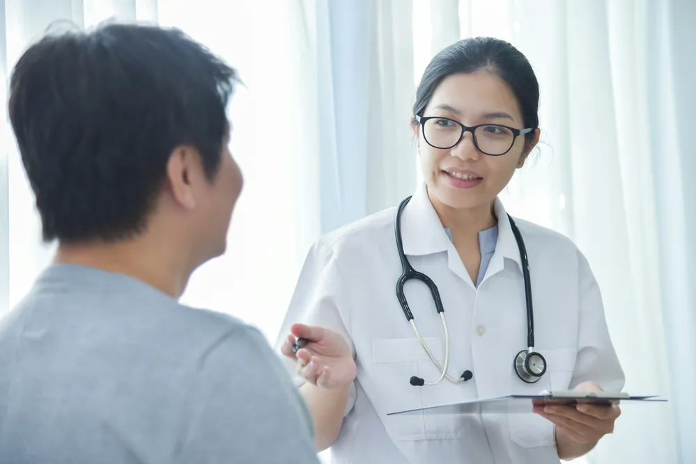 Médecin cardiologue en consultation avec un patient pour évaluer son aptitude sportive