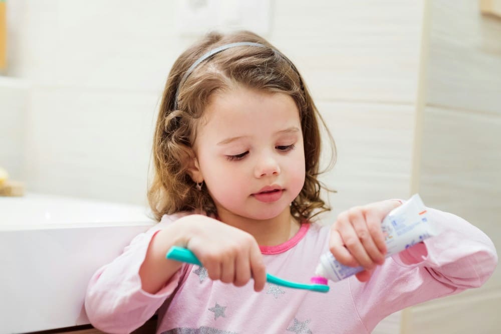 Quel est le meilleur dentifrice, petite fille qui va se laver les dents