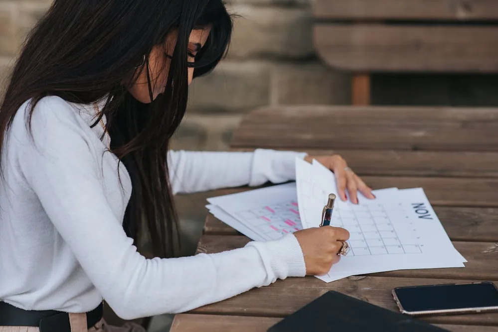 Quand faire un test de grossesse fiable : femme notant ses dates de cycle sur un calendrier