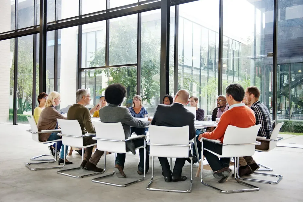 Réunion collaborative d'une équipe de communication santé autour d'une grande table