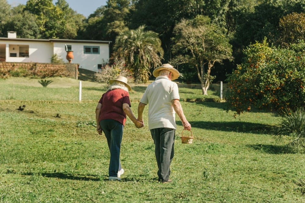 Couple de retraités qui fait sa marche quotidienne dans son jardin