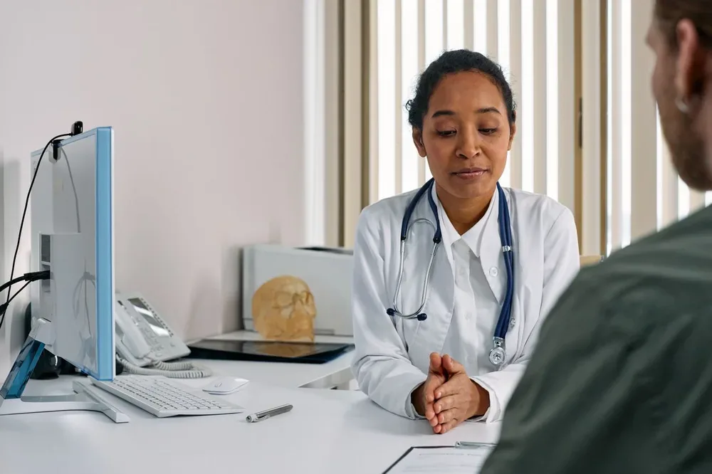 Médecin discutant avec un patient lors d’une consultation en cabinet.