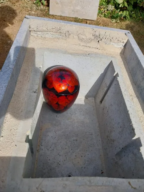 Urne décorative posée dans une cavurne en béton, dans un espace cinéraire.